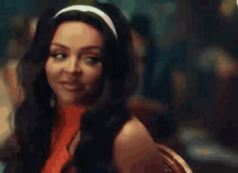 A Woman With Long Hair Is Wearing A Headband And Smiling While Sitting At A Table . GIF