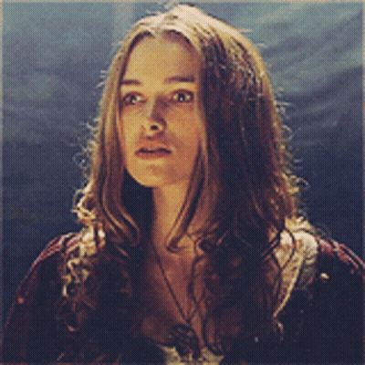A Woman With Long Hair Is Wearing A Necklace And A Red Shirt GIF