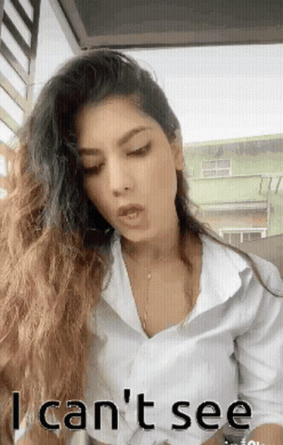 A Woman With Long Hair Is Wearing A White Shirt And Says I Can T See GIF