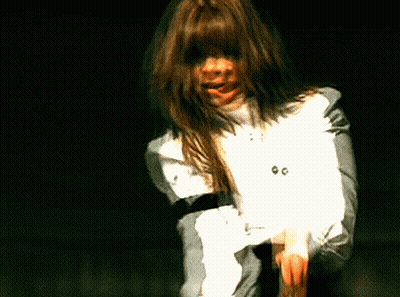 A Woman With Long Hair Is Wearing A White Shirt With The Number 00 On The Front GIF