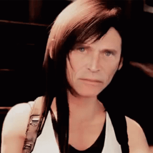 A Woman With Long Hair Is Wearing A White Tank Top And A Black Shirt . GIF