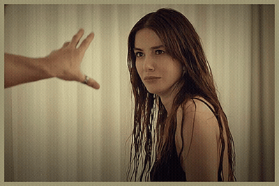 A Woman With Long Hair Looks At A Man 'S Hand Reaching Out GIF
