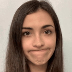 A Woman With Long Hair Making A Face With Her Mouth Open GIF
