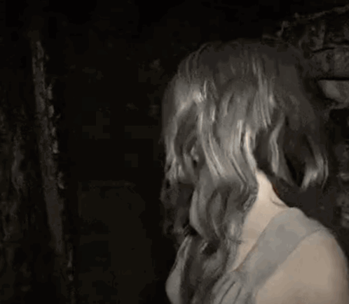 A Woman With Long Hair Stands Next To A Cat That Is Making A Face GIF