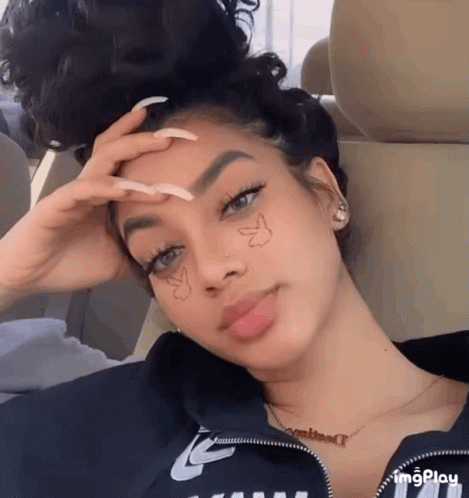 A Woman With Long Nails And A Butterfly On Her Face GIF