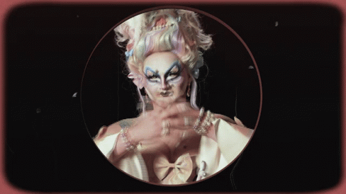 A Woman With Long Nails And Pearls On Her Wrists Is In A Circle GIF