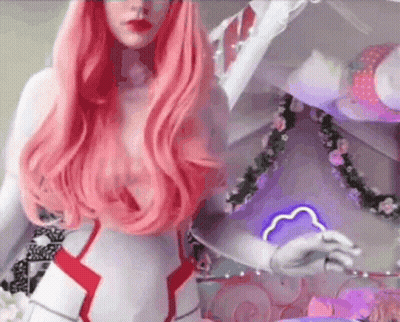A Woman With Long Pink Hair Is Wearing A Costume And Standing In Front Of A Mirror . GIF