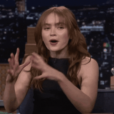 A Woman With Long Red Hair Is Making A Funny Face GIF