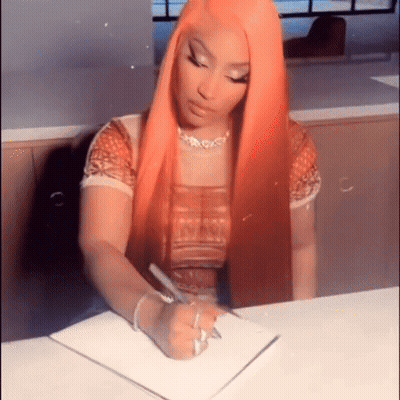 A Woman With Long Red Hair Is Sitting At A Table Writing In A Notebook . GIF
