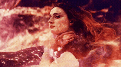 A Woman With Long Red Hair Is Surrounded By Fire GIF