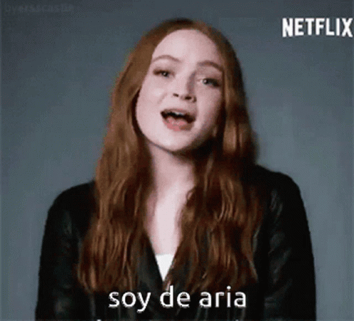 A Woman With Long Red Hair Is Wearing A Black Leather Jacket And Says Soy De Aria . GIF