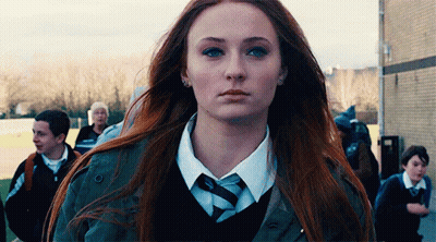 A Woman With Long Red Hair Is Wearing A Tie And A Jacket . GIF