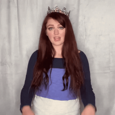 A Woman With Long Red Hair Wearing A Tiara On Her Head GIF