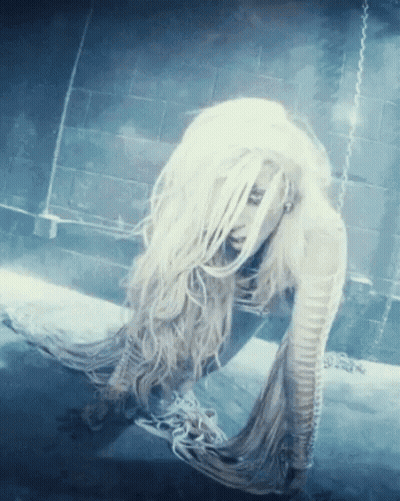A Woman With Long White Hair Is Laying On The Ground GIF