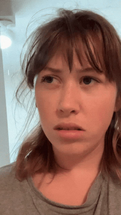 A Woman With Messy Hair Looks At The Camera GIF