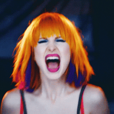 A Woman With Orange And Purple Hair Is Screaming With Her Mouth Open GIF