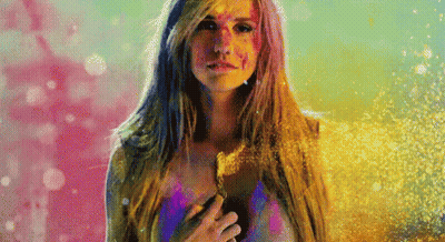 A Woman With Paint On Her Face Is Standing In Front Of A Pink And Blue Background GIF