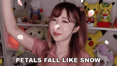 A Woman With Petals Falling On Her Face And The Words Petals Fall Like Snow GIF