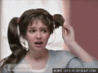 A Woman With Pigtails Is Looking At Her Hair GIF