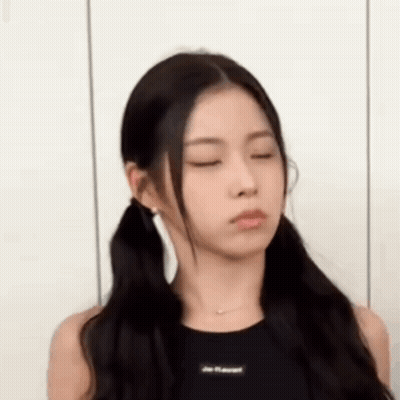 A Woman With Pigtails Is Making A Funny Face . GIF