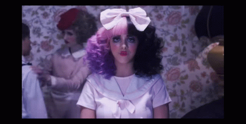 A Woman With Pink And Purple Hair And A White Bow GIF