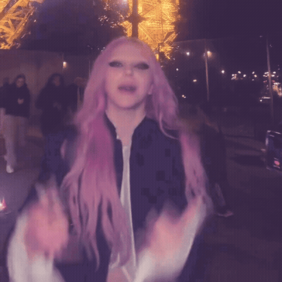 A Woman With Pink Hair And A Black Jacket GIF