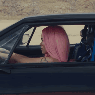 A Woman With Pink Hair And A Heart Tattoo On Her Arm GIF