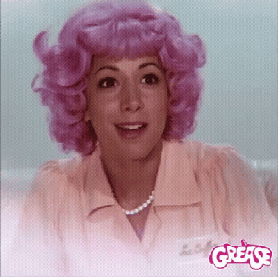 A Woman With Pink Hair And A Name Tag That Says ' Grease ' GIF