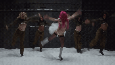 A Woman With Pink Hair Is Dancing In The Snow With Other Women GIF
