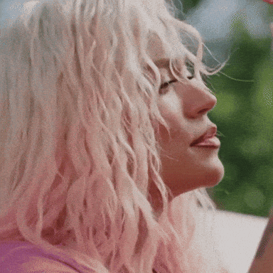 A Woman With Pink Hair Is Looking Up At Something GIF