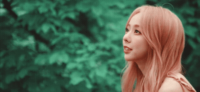 A Woman With Pink Hair Is Looking Up At The Sky GIF