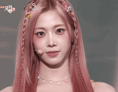 A Woman With Pink Hair Is Making A Face With Her Hands On Her Face . GIF