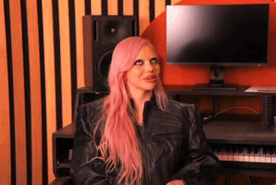 A Woman With Pink Hair Is Sitting In Front Of A Computer GIF