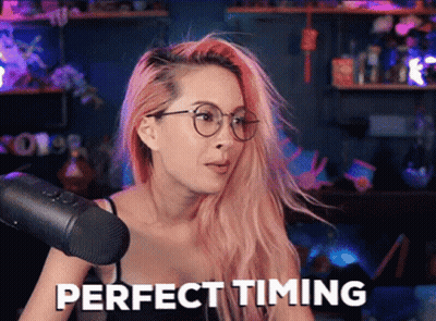 A Woman With Pink Hair Is Sitting In Front Of A Microphone And Says Perfect Timing . GIF