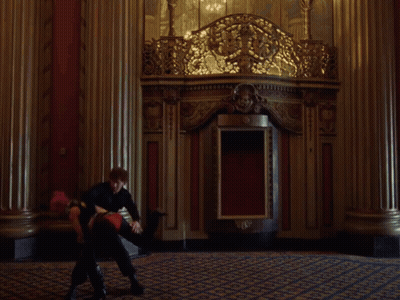 A Woman With Pink Hair Is Standing Next To A Man In A Black Top . GIF