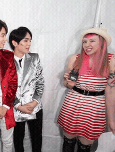 A Woman With Pink Hair Is Standing Next To A Man In A Suit GIF