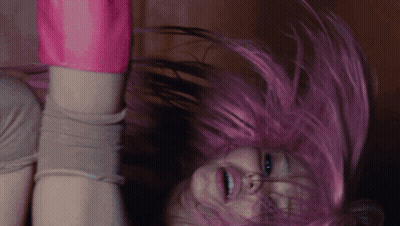 A Woman With Pink Hair Is Upside Down And Smiling GIF