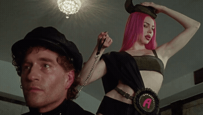 A Woman With Pink Hair Is Wearing A Belt With The Letter A GIF
