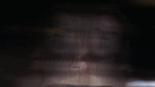 A Woman With Pink Hair Looks At The Camera GIF