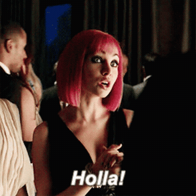 A Woman With Pink Hair Says Holla In A Crowded Room GIF
