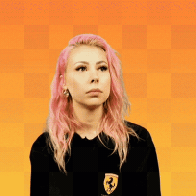 A Woman With Pink Hair Wears A Black Shirt With A Ferrari Logo On It GIF