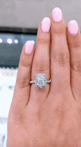 A Woman With Pink Nails Is Wearing A Diamond Ring On Her Left Hand GIF