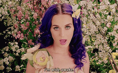 A Woman With Purple Hair And A Flower In Her Hair Says " I 'M Wide Awake " GIF