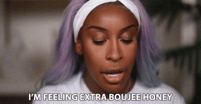 A Woman With Purple Hair And A Headband Says I 'M Feeling Extra Boujee Honey GIF