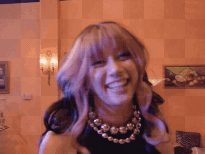 A Woman With Purple Hair And A Necklace Is Smiling GIF