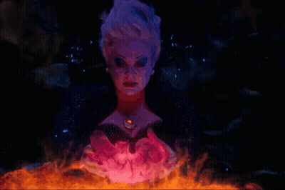A Woman With Purple Hair And A Necklace With A Red Stone GIF