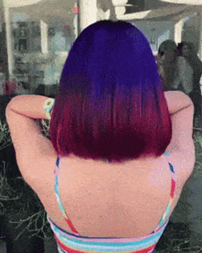 A Woman With Purple Hair And A Rainbow Tank Top GIF
