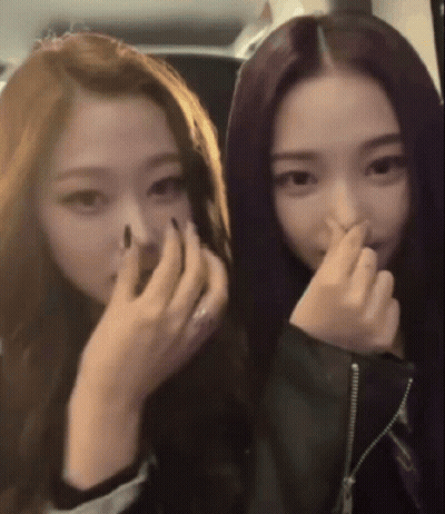 A Woman With Purple Hair Is Covering Her Nose With Her Hand GIF
