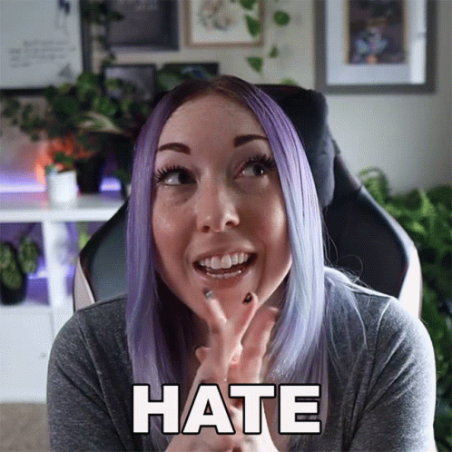 A Woman With Purple Hair Is Making A Face And The Word Hate Is On The Screen GIF