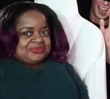 A Woman With Purple Hair Is Smiling While Sitting Next To A Man In A White Shirt . GIF